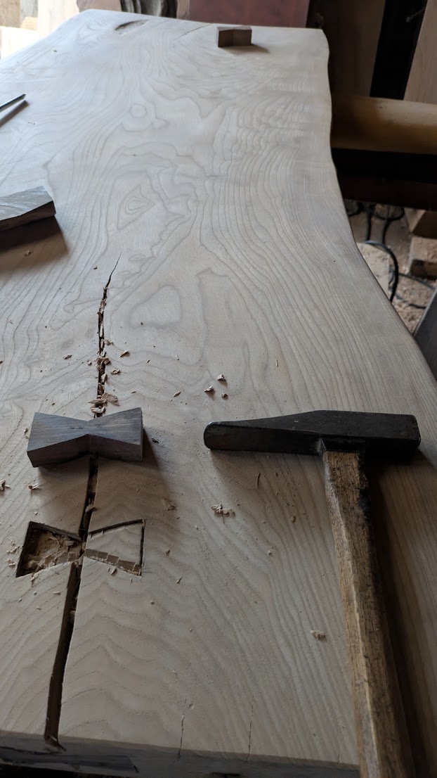 Chigiri (butterfly key) being fitted into a crack in a slab